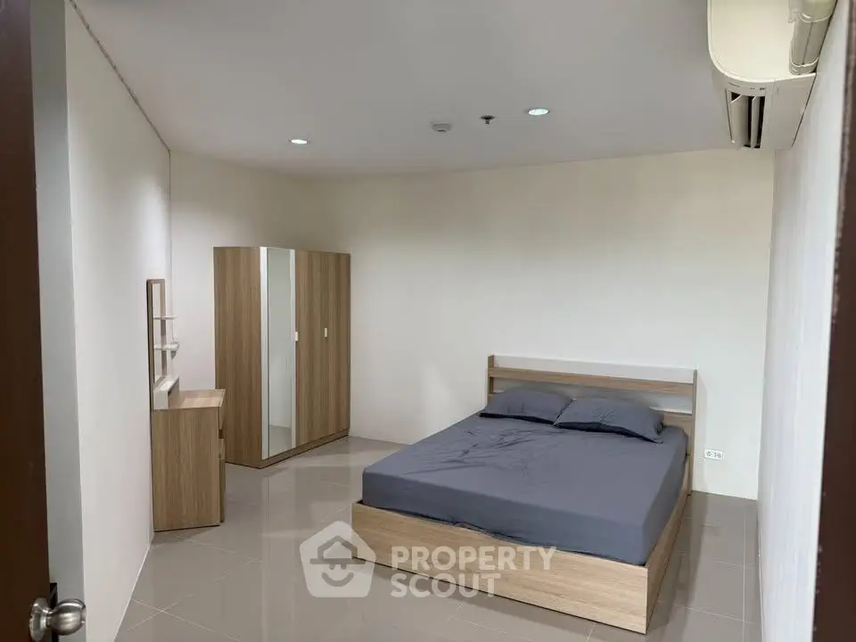 Spacious bedroom with modern furniture and sleek design, perfect for comfortable living.