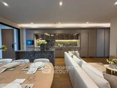 Luxurious open-plan kitchen and living room with elegant dining setup and modern decor.