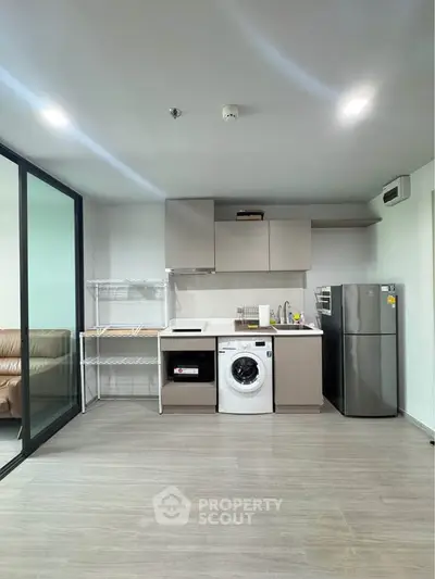 Modern kitchen with washing machine and fridge in open layout apartment