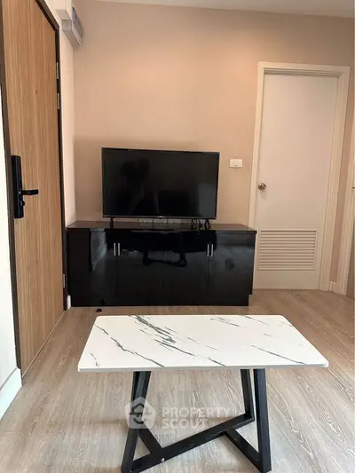 Modern living room with sleek TV stand and stylish marble coffee table.