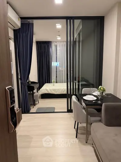Modern open-plan apartment with stylish living and dining area, featuring floor-to-ceiling windows and elegant decor.