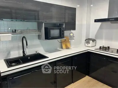 Modern kitchen with sleek black cabinetry and high-end appliances