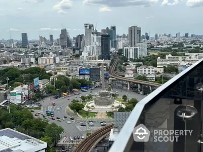 Stunning cityscape view from high-rise balcony overlooking urban skyline and bustling roundabout.