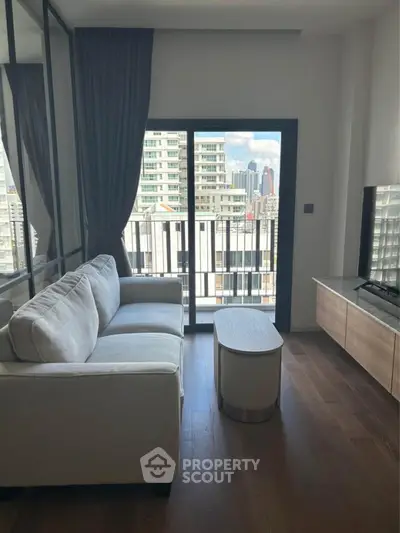 Modern living room with city view, featuring a cozy sofa and sleek furniture.