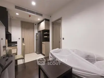 Modern apartment interior with sleek furniture and compact kitchen design.