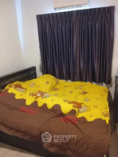 Cozy bedroom with vibrant cartoon-themed bedding and dark curtains, perfect for a playful touch.