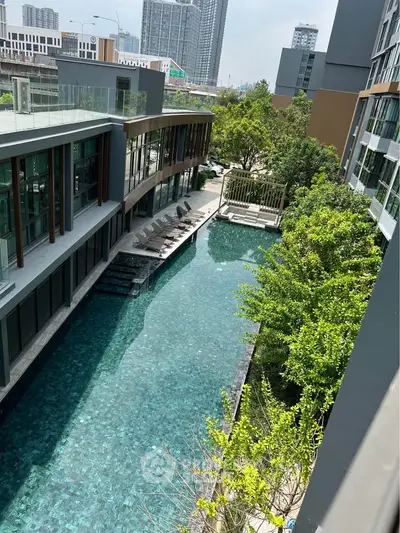 Luxurious modern apartment complex with stunning pool and lush greenery, perfect for urban living.
