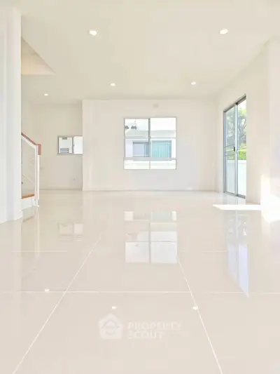 Spacious modern living room with large windows and glossy tile flooring, perfect for natural light lovers.