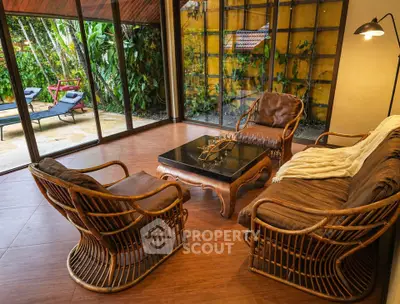 Charming living room with rattan furniture and garden view, perfect for relaxation and entertaining.