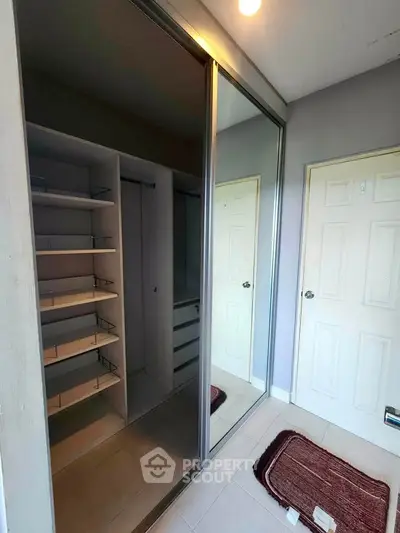 Spacious walk-in closet with mirrored sliding doors and ample shelving in modern home.