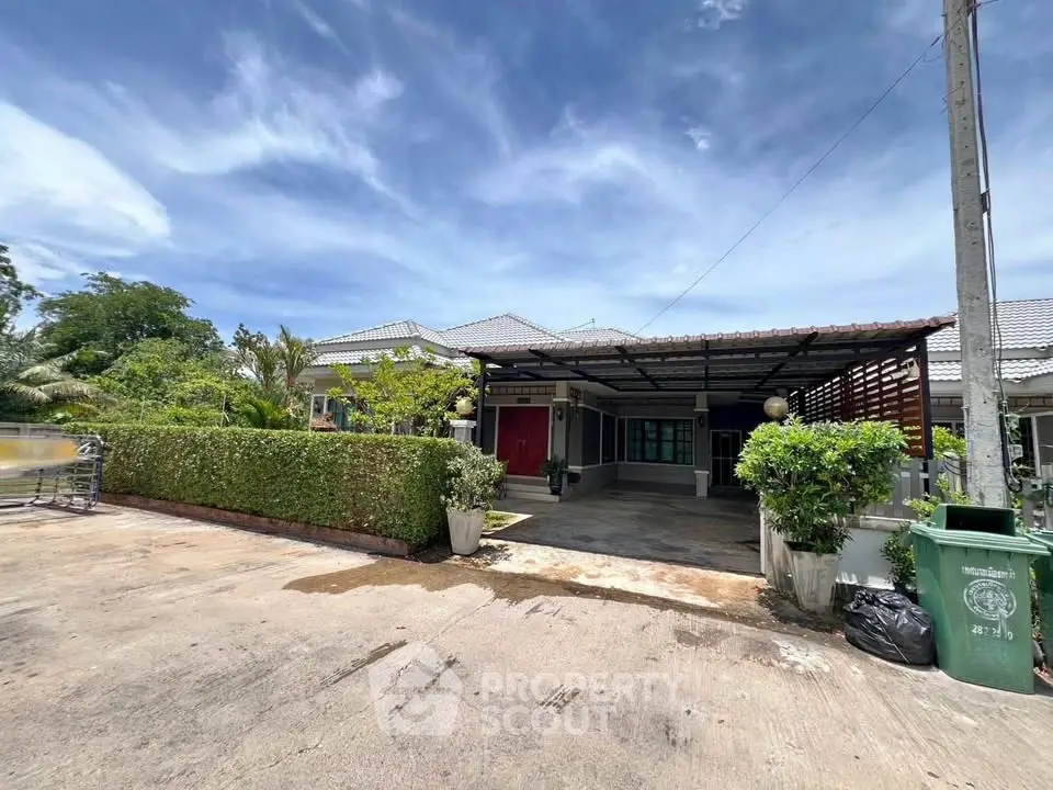 Charming single-story home with spacious driveway and lush greenery, perfect for serene living.