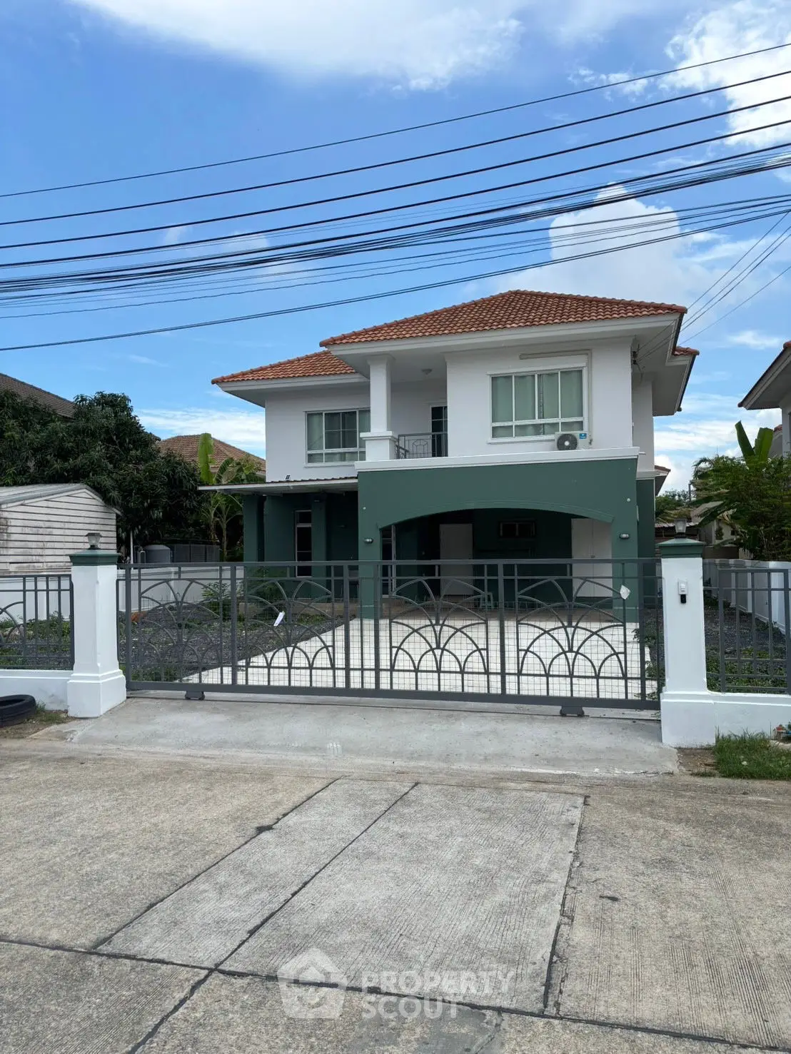 Charming two-story house with gated entrance and spacious driveway in a serene neighborhood.