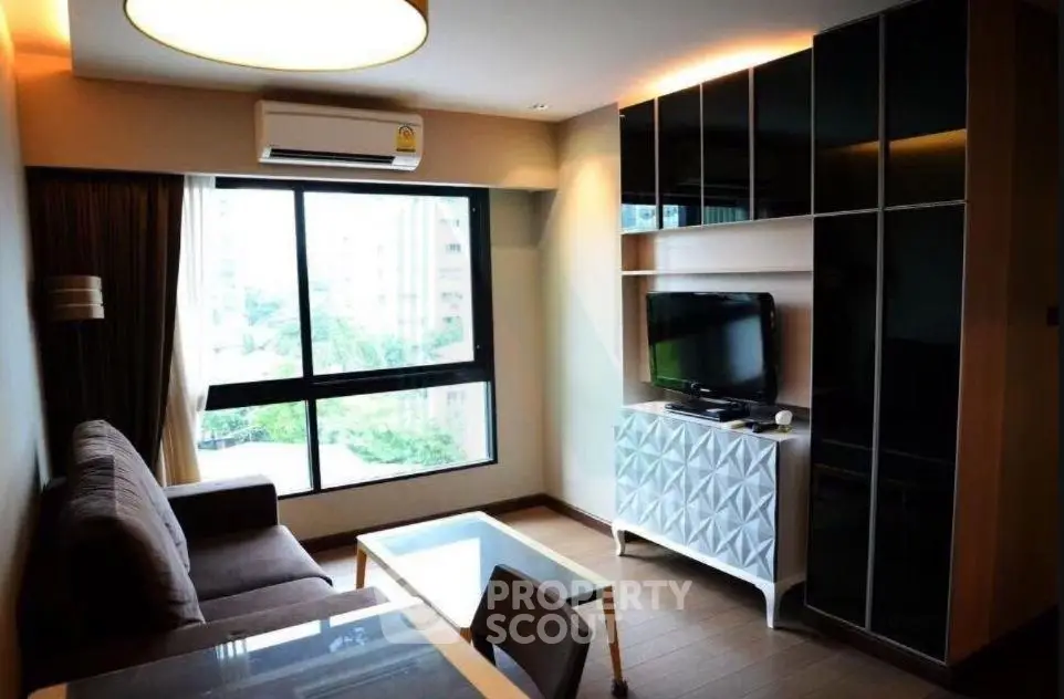 Modern living room with large window and stylish furniture in urban apartment.