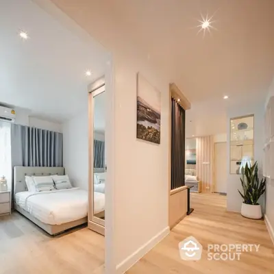 Modern bedroom with stylish decor and ample natural light, featuring a cozy bed and elegant wooden flooring.