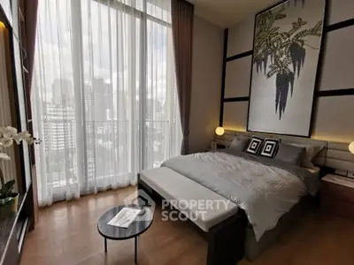 Luxurious bedroom with floor-to-ceiling windows offering stunning city views and elegant decor.
