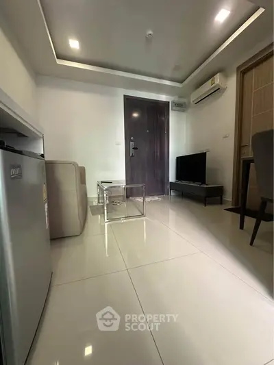 Modern living room with sleek design, featuring a mini fridge, TV, and air conditioning for ultimate comfort.