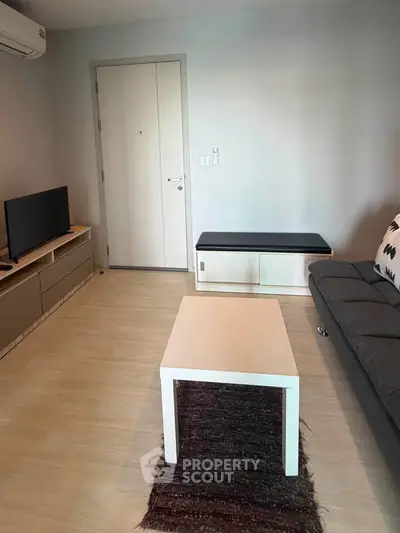 Modern living room with sleek furniture and minimalist design, featuring a cozy sofa and stylish TV unit.