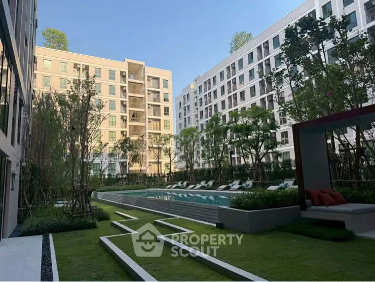 Modern residential building with landscaped garden and outdoor seating area.