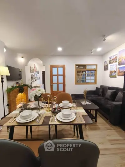 Charming living room with cozy dining area, modern decor, and elegant table setting in a stylish apartment.