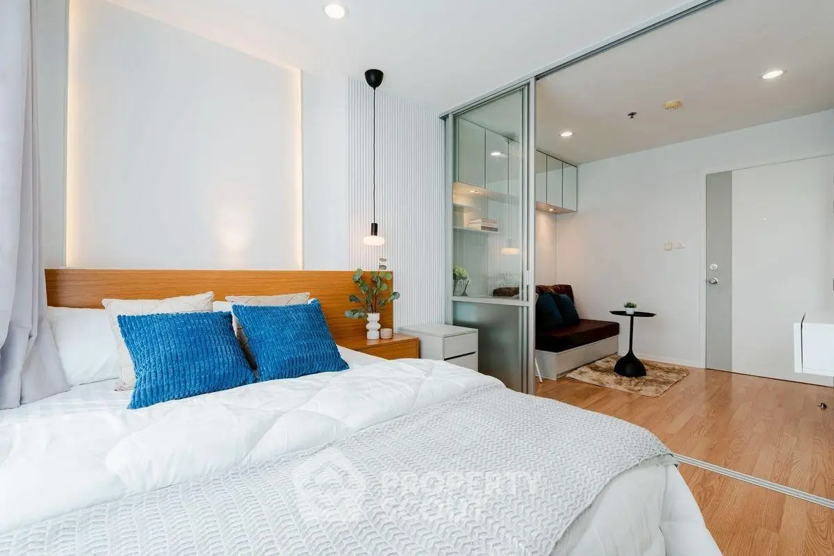 Modern bedroom with cozy decor and sliding glass doors leading to a study area.