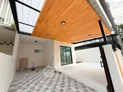 Modern covered patio with stylish wood ceiling and tiled flooring in contemporary home.