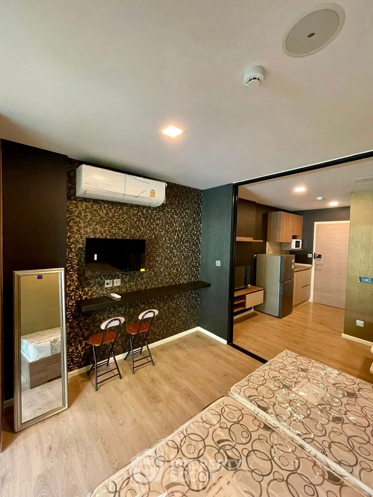 Modern studio apartment with stylish decor, featuring a compact kitchen and cozy living area.