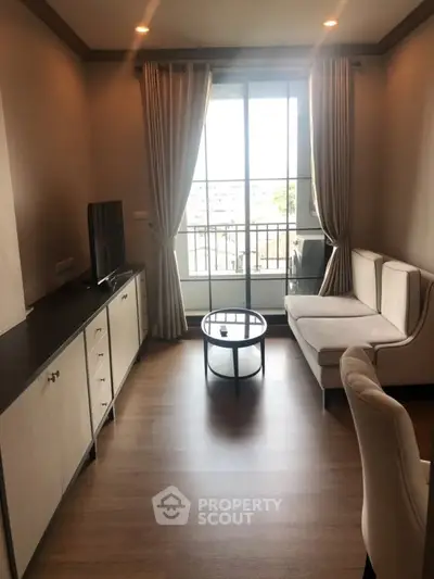 Chic living room with modern furniture and large window offering natural light and city views.