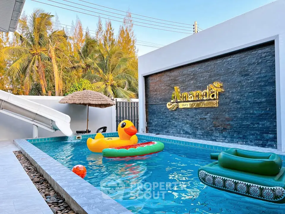 Luxurious private pool with playful inflatables and modern design in tropical setting.