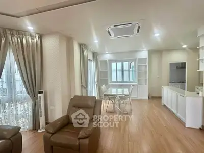 Spacious living room with modern furniture and open layout in a bright apartment.
