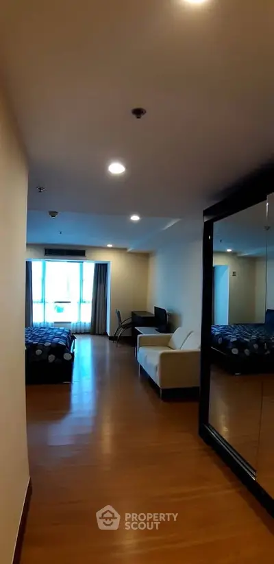 Spacious studio apartment with modern furnishings and large windows offering natural light.