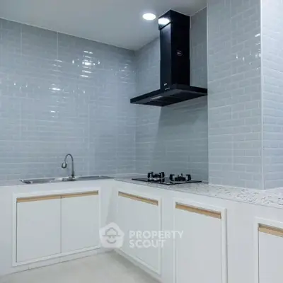 Modern kitchen with sleek cabinets and gas stove in a stylish open layout.