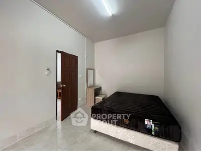 Spacious bedroom with minimalist decor and comfortable bed in modern apartment.