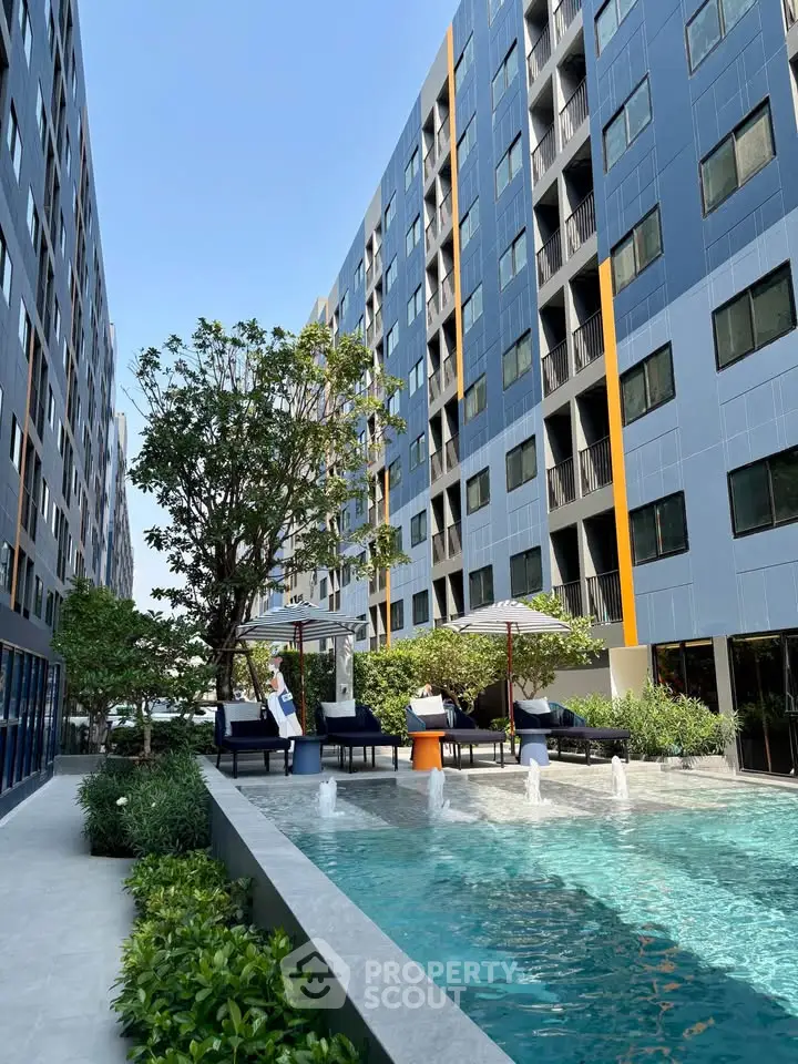 Modern apartment complex with pool and lounging area, perfect for relaxation and leisure.