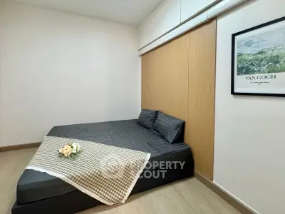 Cozy minimalist bedroom with modern decor and Van Gogh artwork, perfect for relaxation.