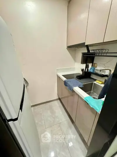 Compact modern kitchen with sleek cabinetry and stainless steel appliances