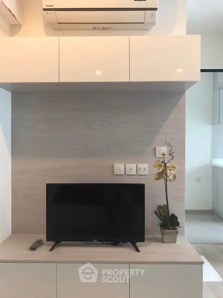 Modern living room with sleek TV setup and air conditioning unit