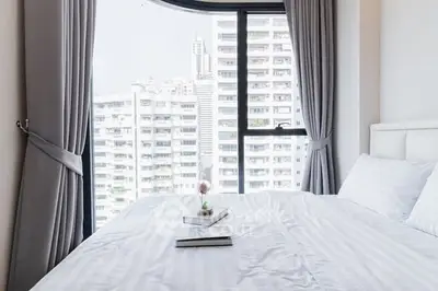 Bright bedroom with city view and elegant curtains