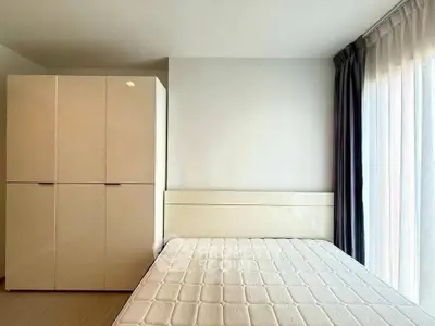 Modern bedroom with large wardrobe and natural light from floor-to-ceiling window.