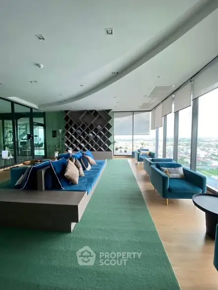 Luxurious living room with panoramic city views and modern blue seating.