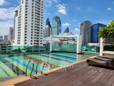 Luxurious rooftop pool with stunning city skyline views in modern high-rise building.