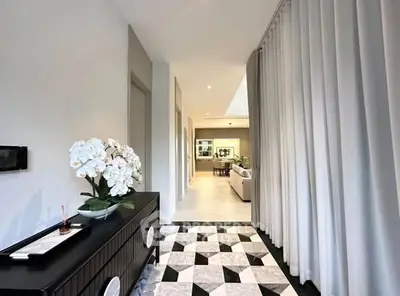 Elegant hallway with modern decor leading to a spacious living area, featuring stylish flooring and ambient lighting.