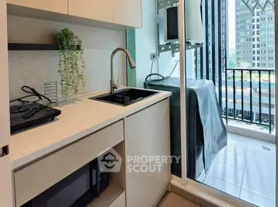 Modern kitchen with sleek design and balcony view, featuring compact appliances and stylish fixtures.