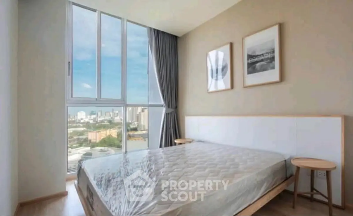Modern bedroom with large window offering stunning city views and minimalist decor.