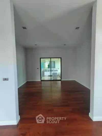 Spacious interior with elegant wooden flooring and modern kitchen view