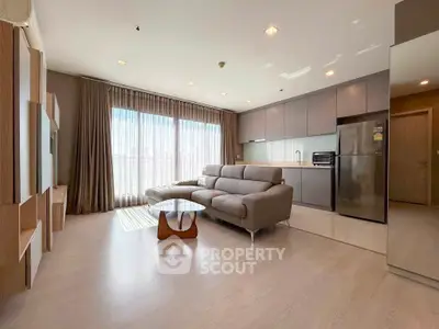 Spacious modern living room with sleek kitchen and large windows for natural light.