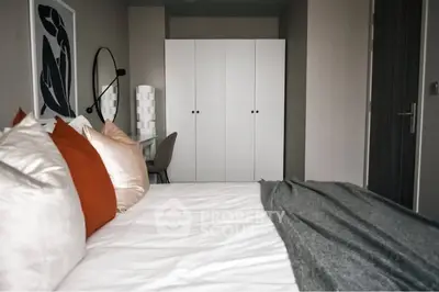Modern bedroom with stylish decor and cozy bedding in a contemporary apartment.