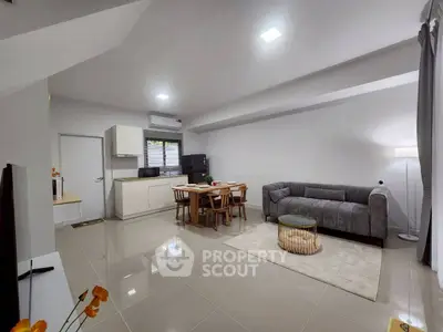 Modern open-plan living room with sleek kitchen and cozy seating area, perfect for contemporary living.