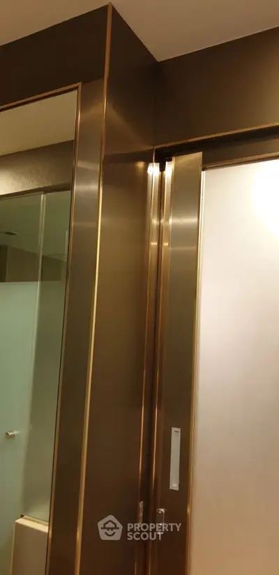 Luxurious bathroom with sleek metallic accents and frosted glass door