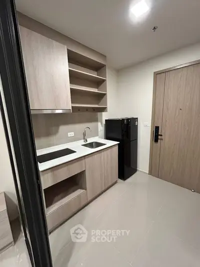 Modern kitchen with sleek cabinetry and compact design in a contemporary apartment.