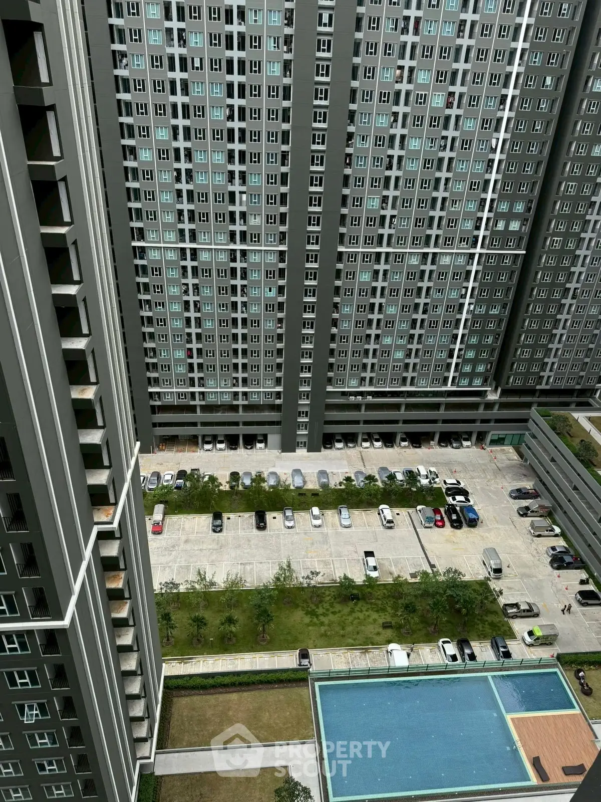 High-rise residential building with pool and parking area view